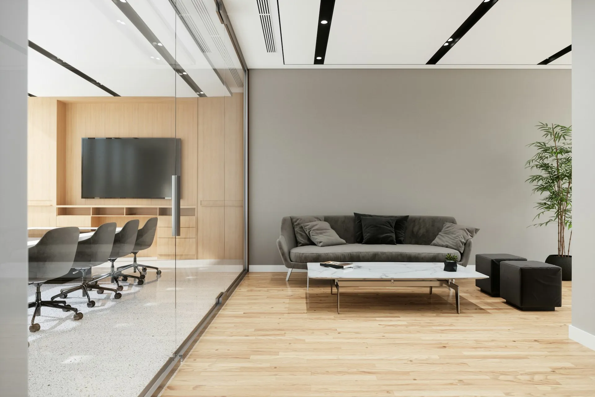 Modern commercial office with boardroom visible through a glass partition and a minimal lounge area